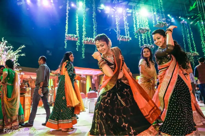 Guests performing traditional dances during a vibrant Sangeet celebration, featured in the Indian Wedding Guide on Indian wedding traditions and events.