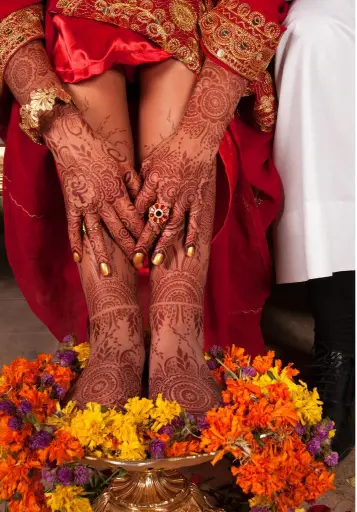 Close-up of a bride's hands and feet adorned with intricate mehndi (henna) designs during an Indian wedding, featured in the Indian Wedding Guide.