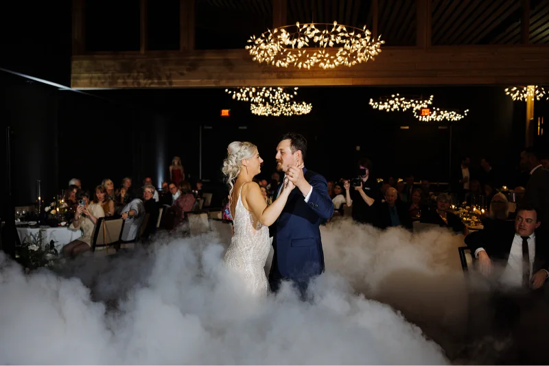 Bride and groom sharing their first dance during a Black Butte Ranch wedding reception surrounded by low-lying fog and elegant lighting.