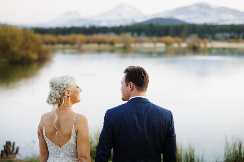 Bride and groom overlooking the lake and Cascade Mountains during a Black Butte Ranch wedding in Central Oregon.