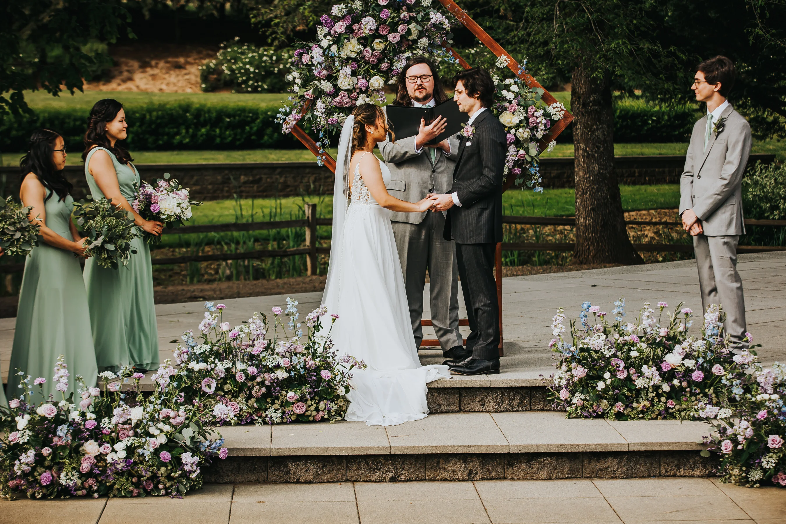 Bride and groom exchanging vows during an outdoor Aurora Vineyards wedding ceremony in Oregon.