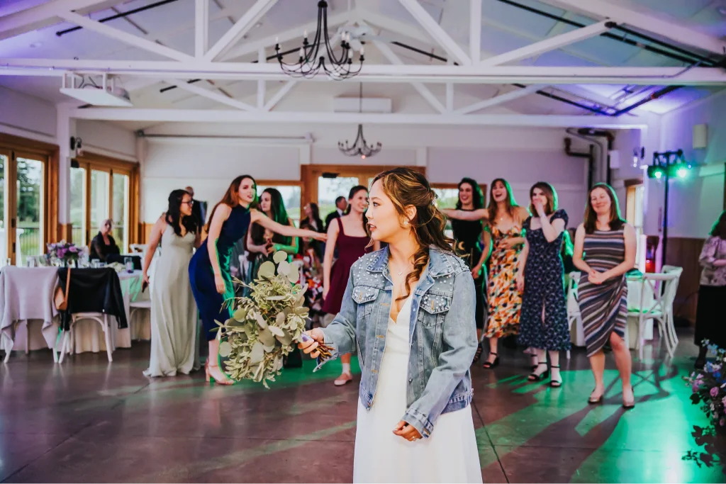 Bride preparing to toss her bouquet during the wedding reception at Aurora Vineyards in Oregon.