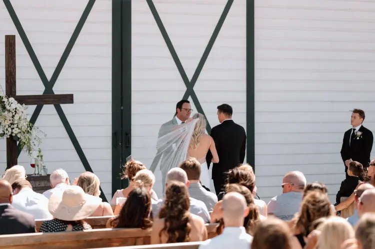 Bride and groom exchanging vows during an outdoor Butler Barn wedding ceremony in Oregon.