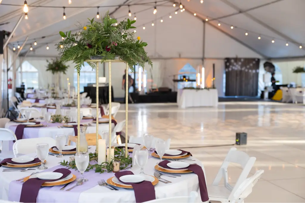 Elegant wedding reception at Camp Cedar Ridge featuring a beautifully decorated tent with string lights, floral centerpieces, and a spacious dance floor.