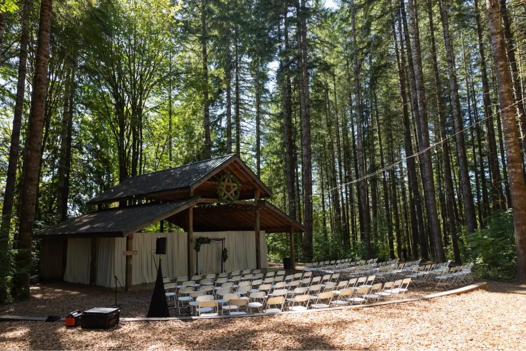 Outdoor wedding ceremony venue at Camp Cedar Ridge surrounded by towering evergreen trees in Oregon.
