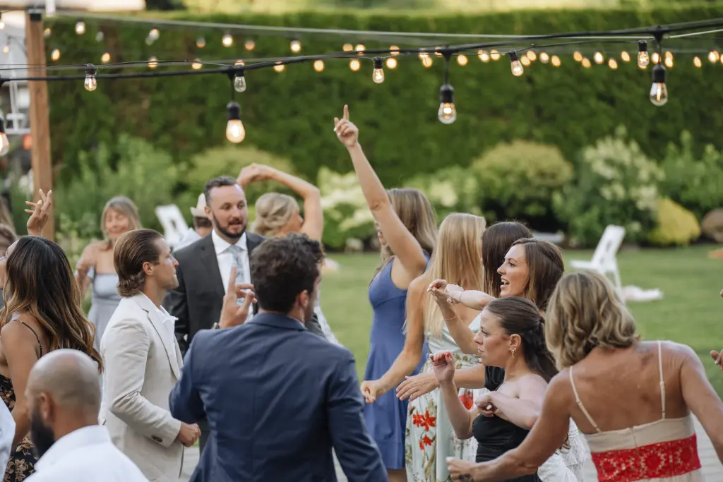 Wedding guests dancing under café string lights during an outdoor reception at Cape Horn Estate in Washington.