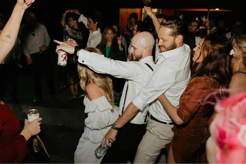 Bride, groom, and wedding guests dancing together during a lively reception at a Wedding at Cedarville Lodge.
