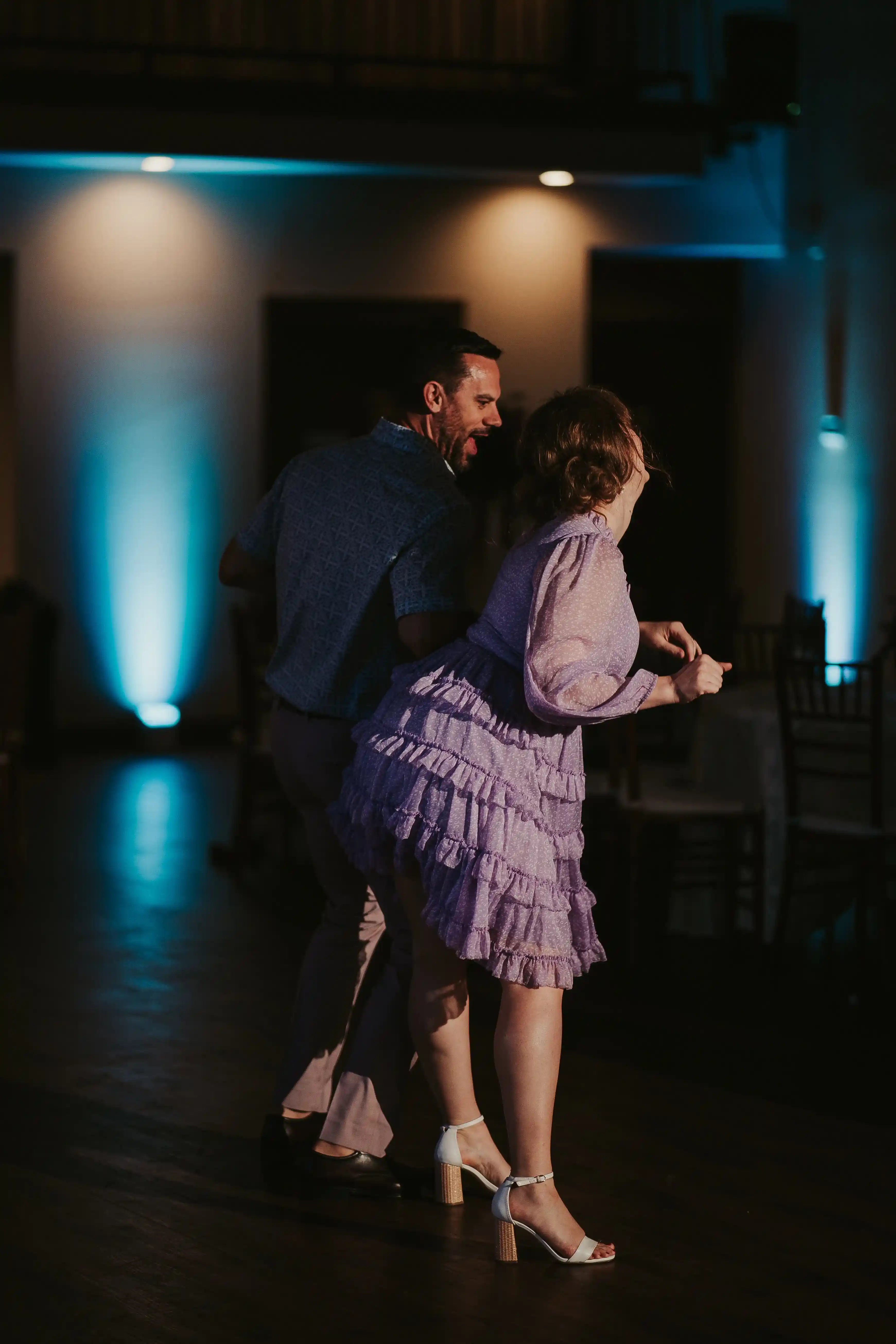 Guests-enjoying-the-dance-floor-during-an-Ecotrust-Building-wedding-reception-in-Portland-with-ambient-blue-uplighting.