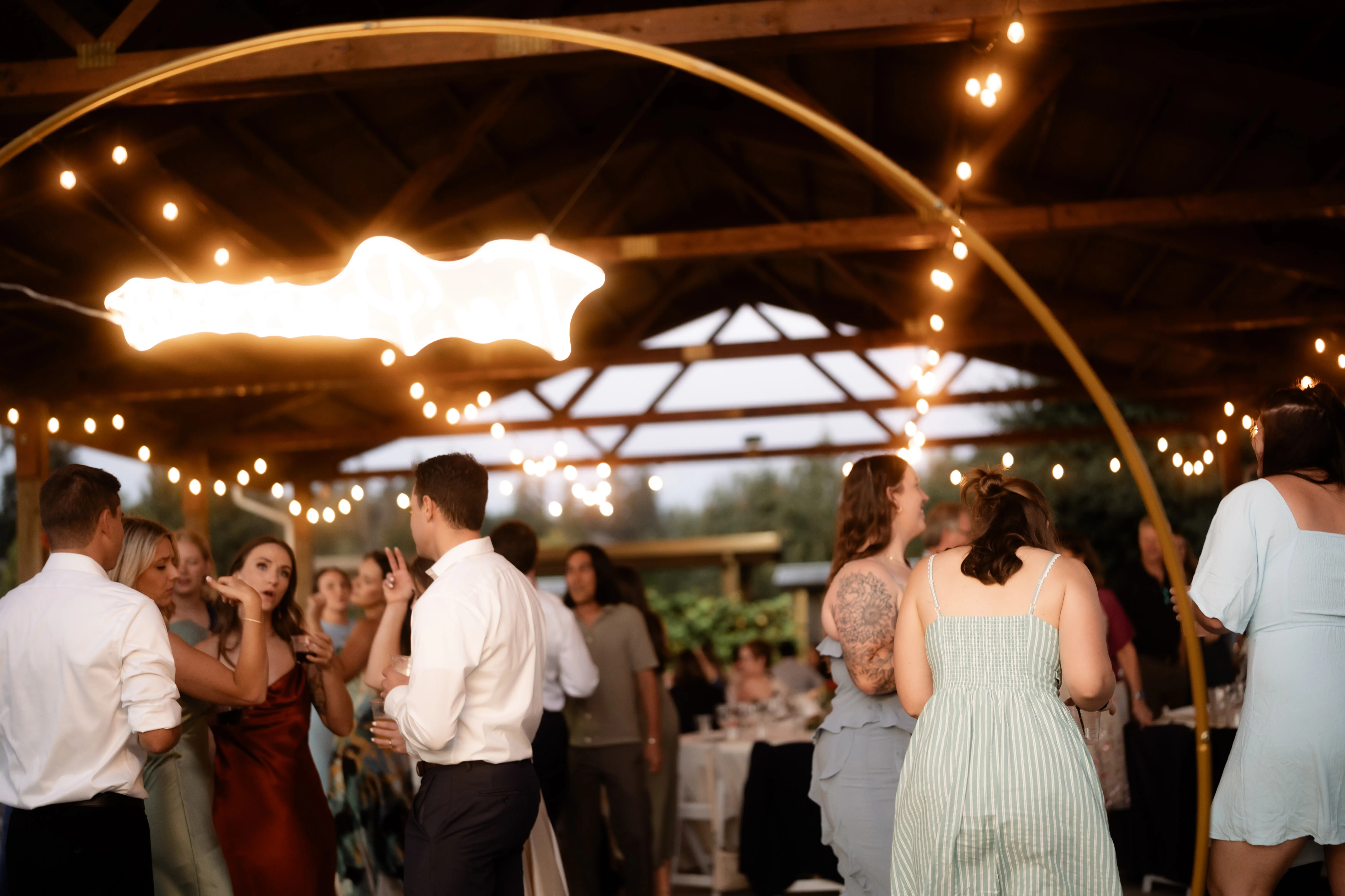 Wedding-guests-celebrating-on-the-dance-floor-during-a-Jacquot-Vineyard-wedding-reception-under-string-lights-in-Oregon.