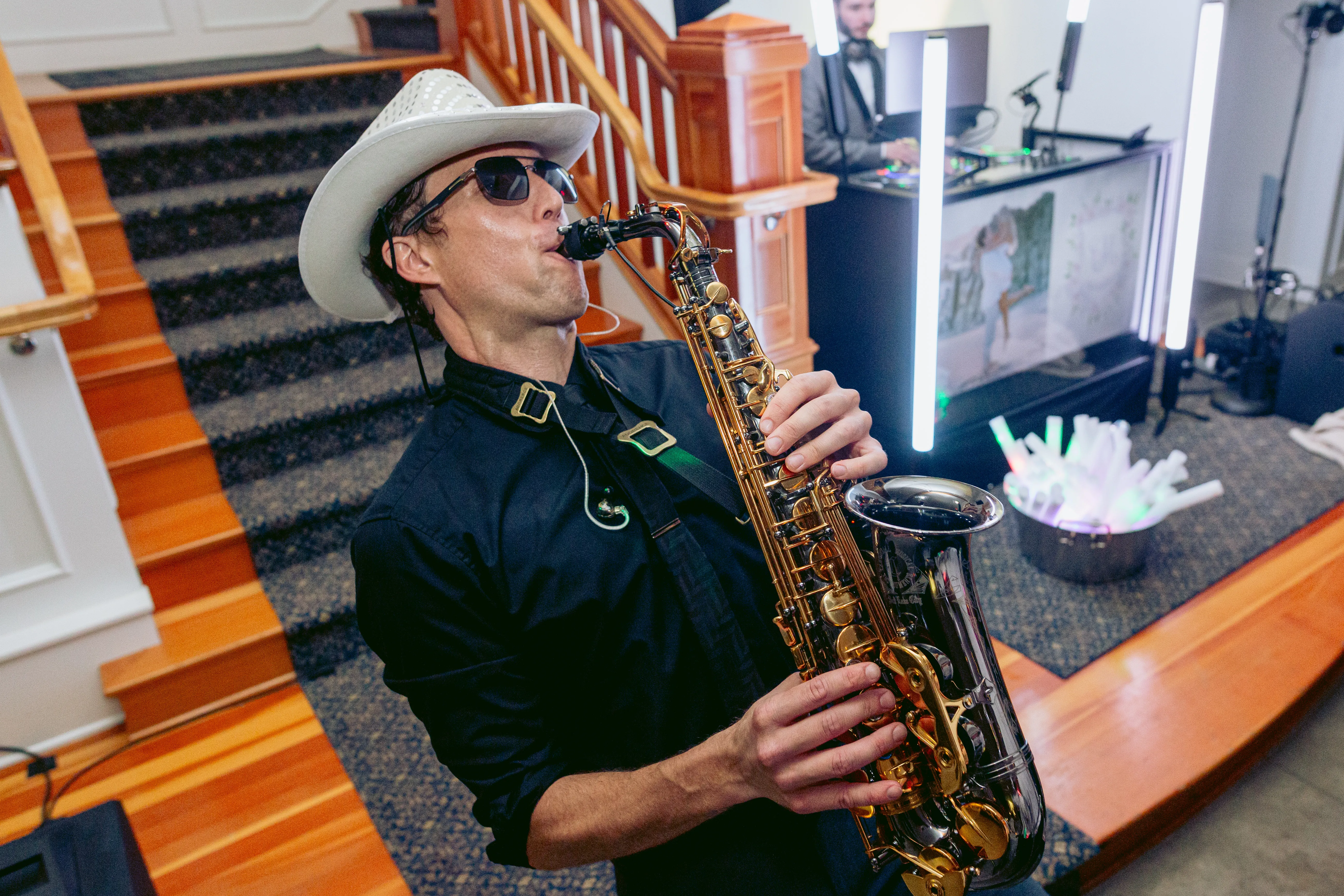 Professional saxophonist performing live during a wedding reception while the DJ plays music, creating an energetic and interactive entertainment experience for guests.