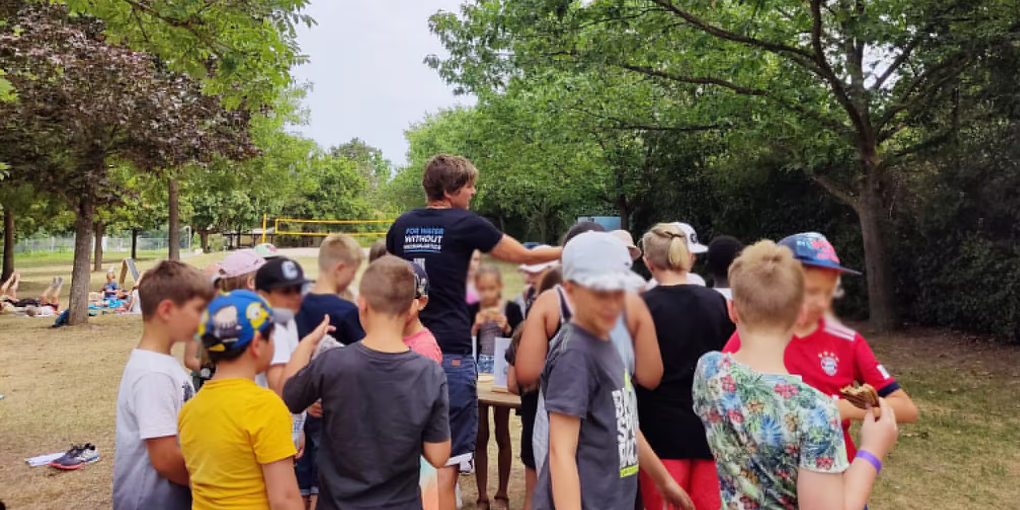 Children conducting a water experiment with microplastic clumps during a Wasser 3.0 educational workshop.
