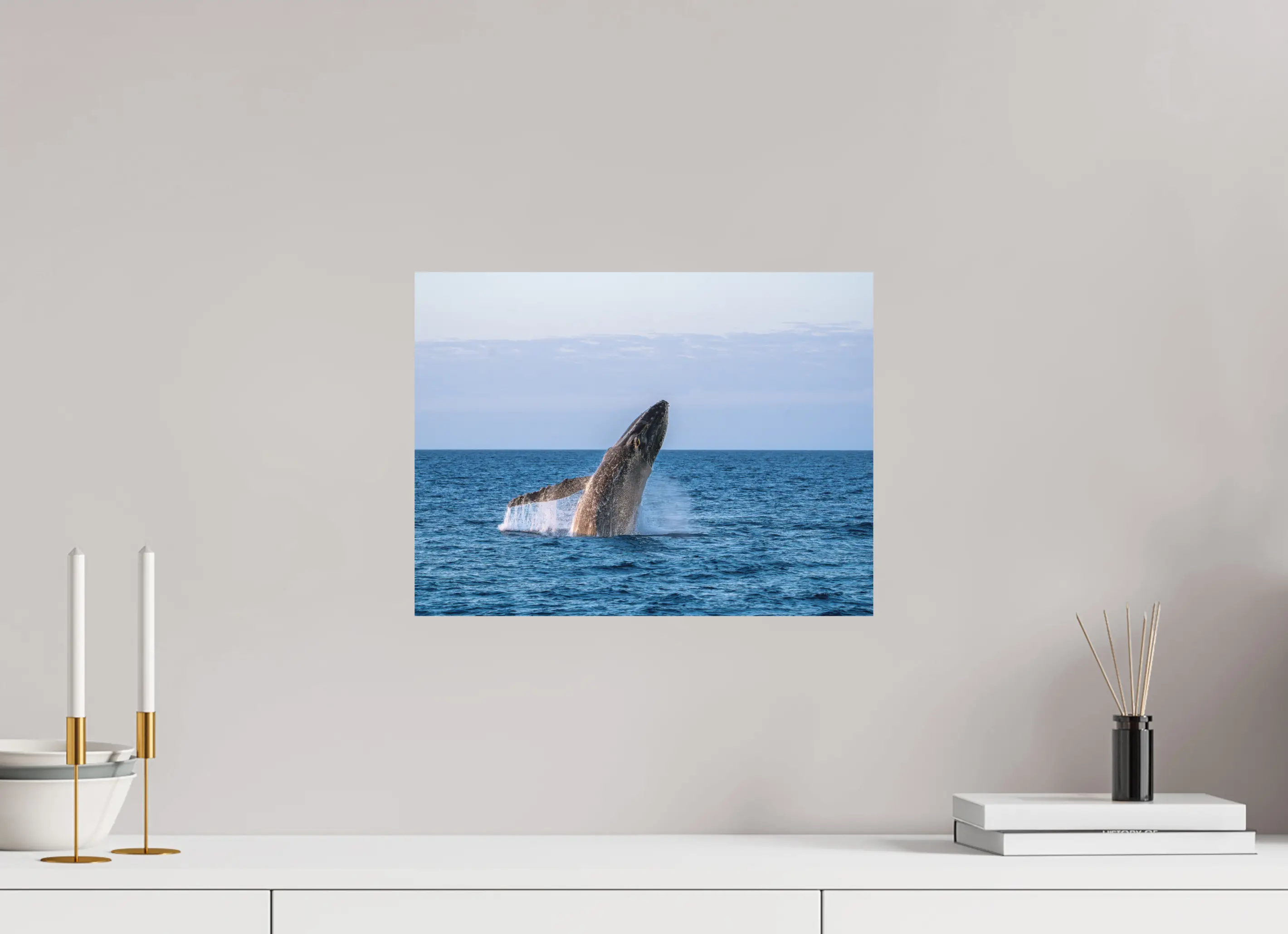 Fine art print “Unleashed” featuring a humpback whale breaching powerfully from the ocean surface, displayed on aluminium dibond in a modern living room setting.