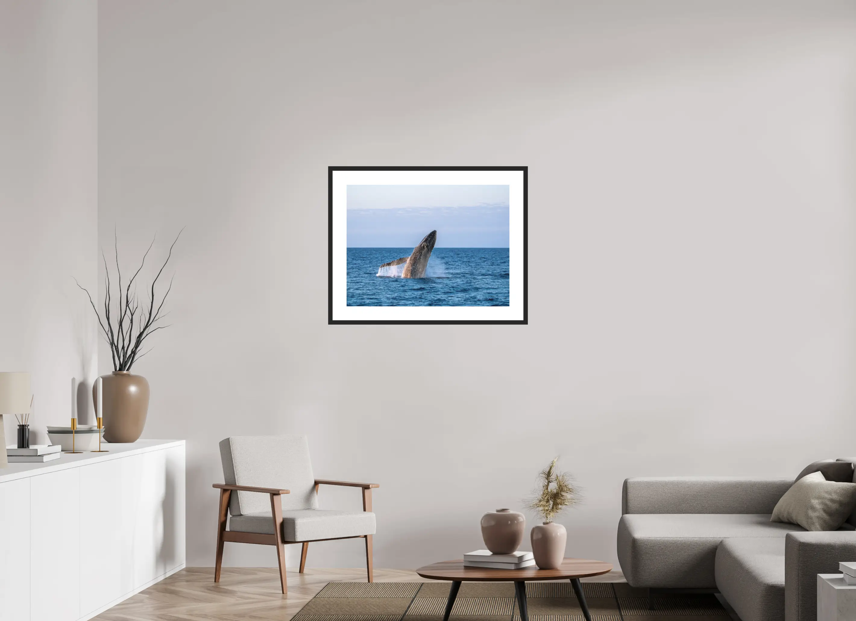Fine art print “Unleashed” featuring a humpback whale breaching powerfully from the ocean surface, displayed in a passepartout frame in a modern living room setting.