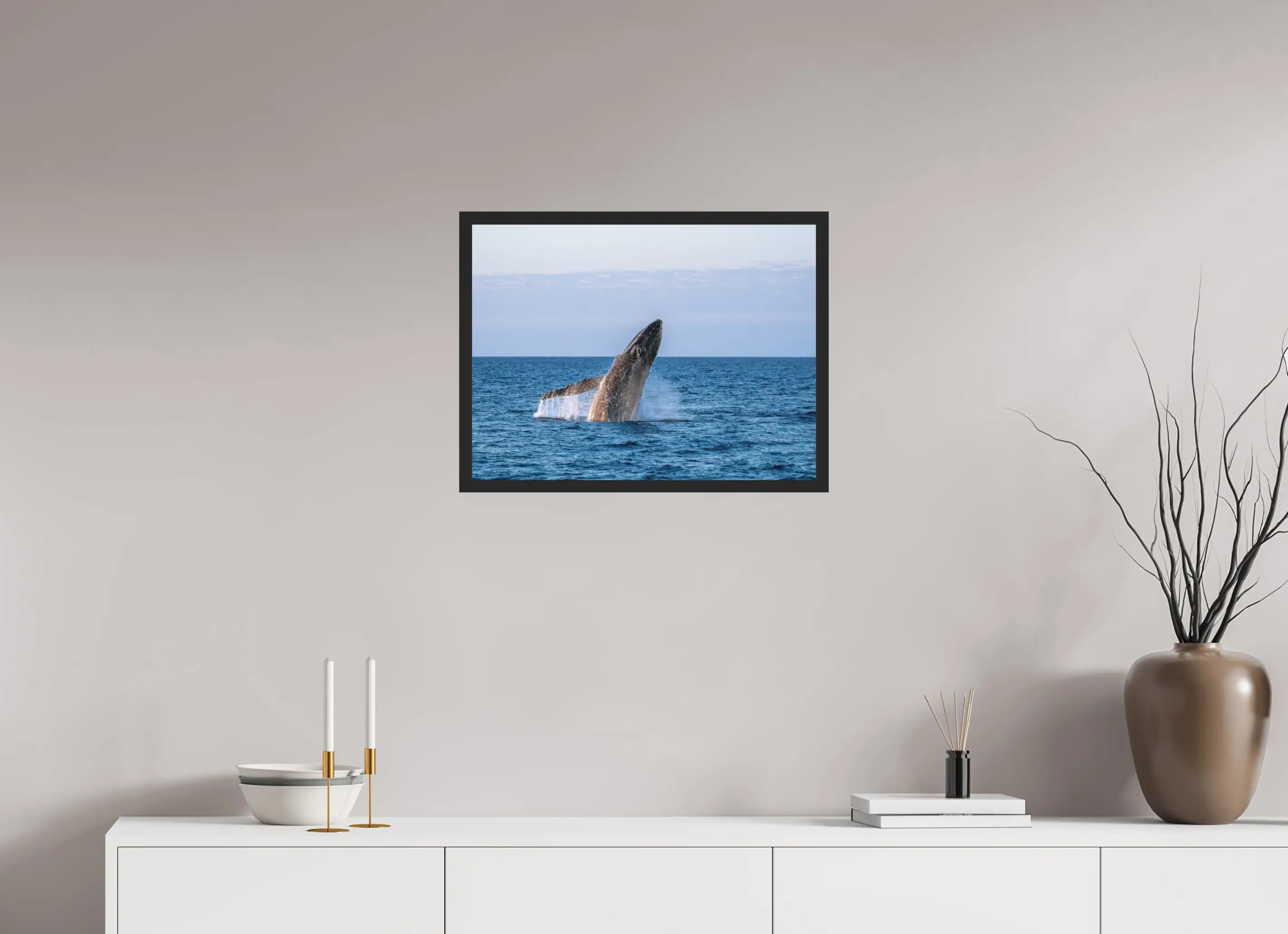 Fine art print “Unleashed” featuring a humpback whale breaching powerfully from the ocean surface, displayed classic framed in a modern living room setting.