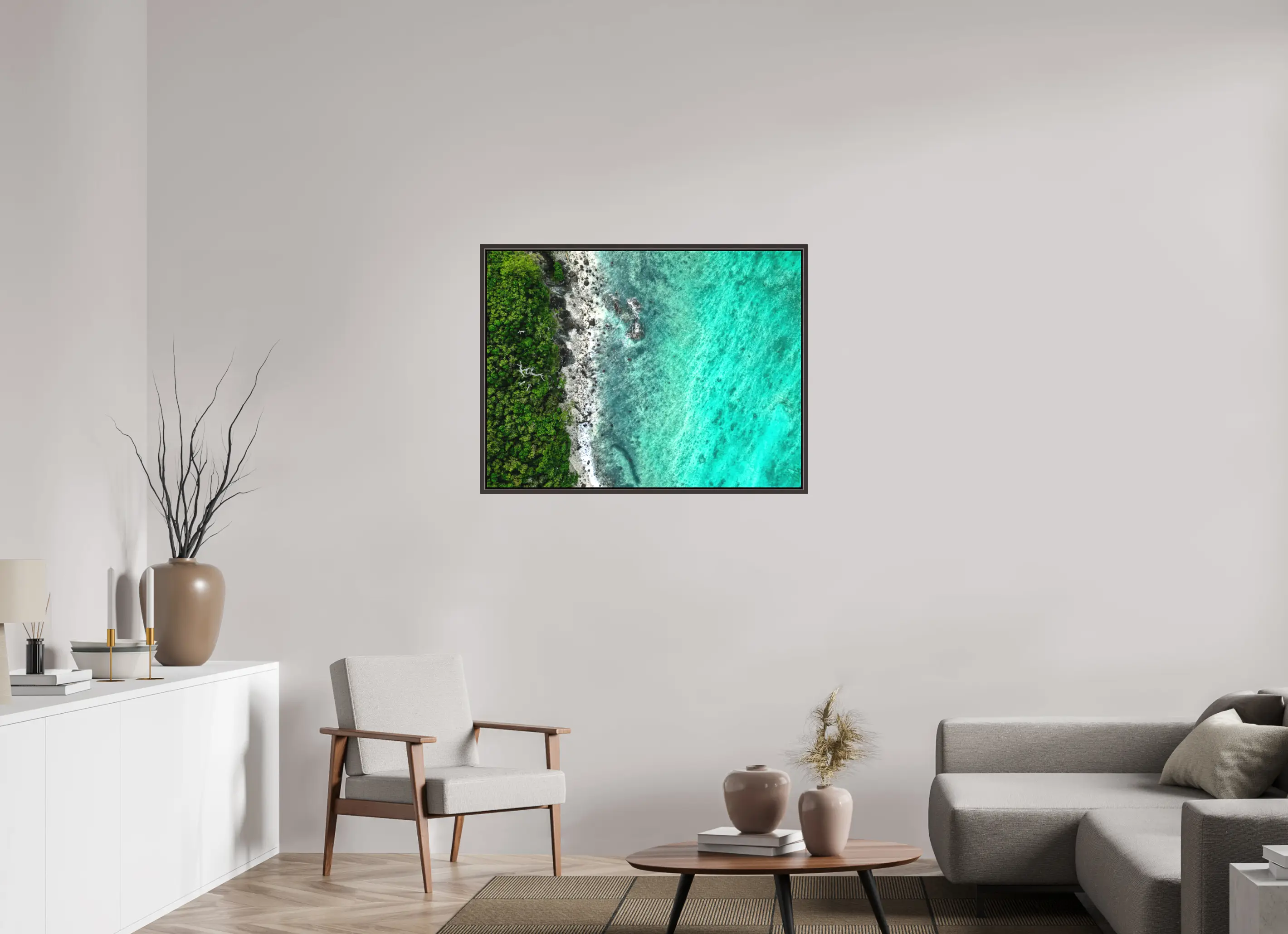 Framed canvas of aerial photograph of a lush green jungle meeting a coral-rich turquoise sea, with waves gently breaking along a rocky tropical shoreline.