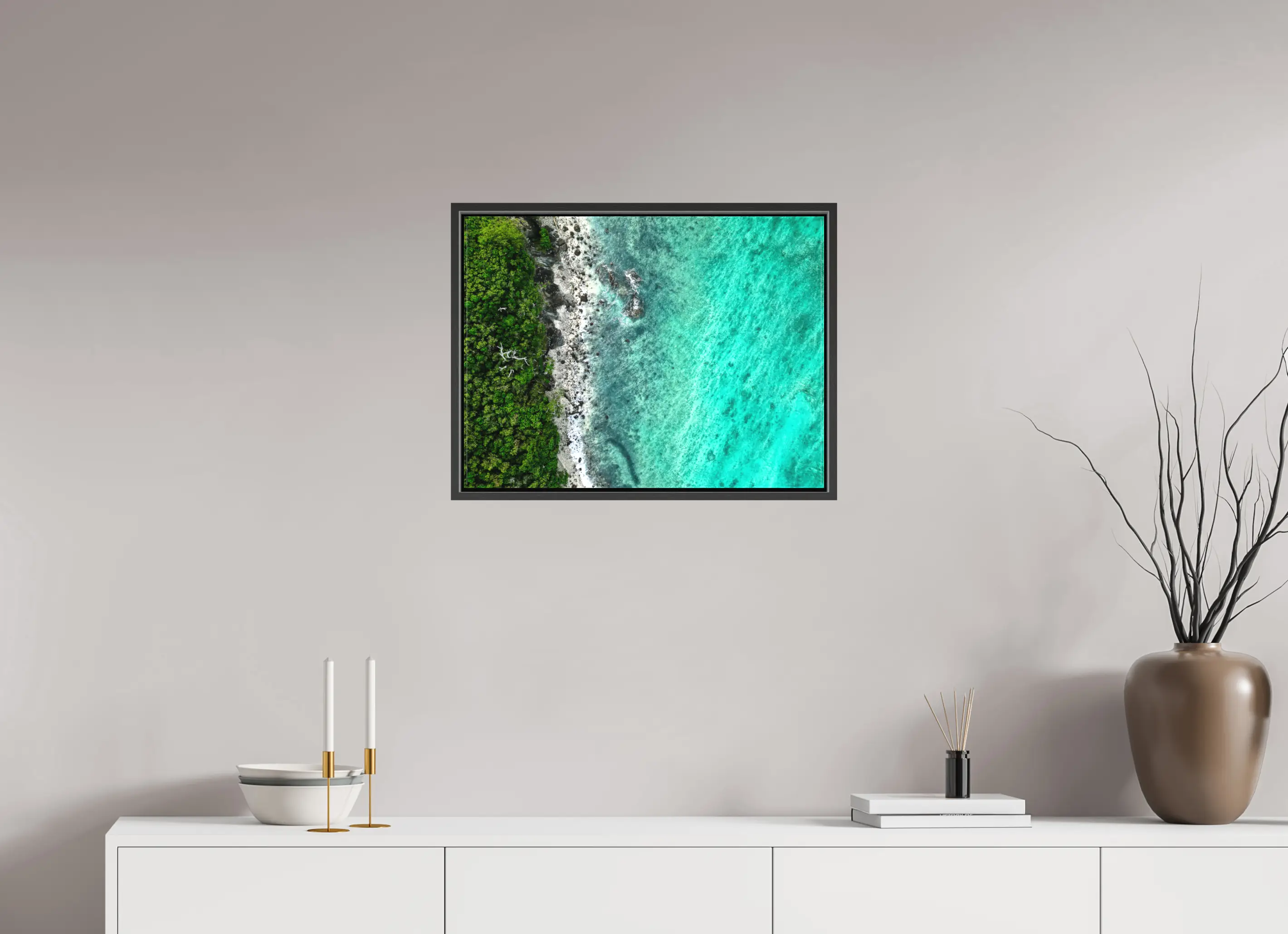 Fine art print “Tropical Jungle meets Coral Sea” featuring aerial view of lush green tropical forest meeting turquoise coral waters, displayed on a premium framed canvas print in a modern living room setting.