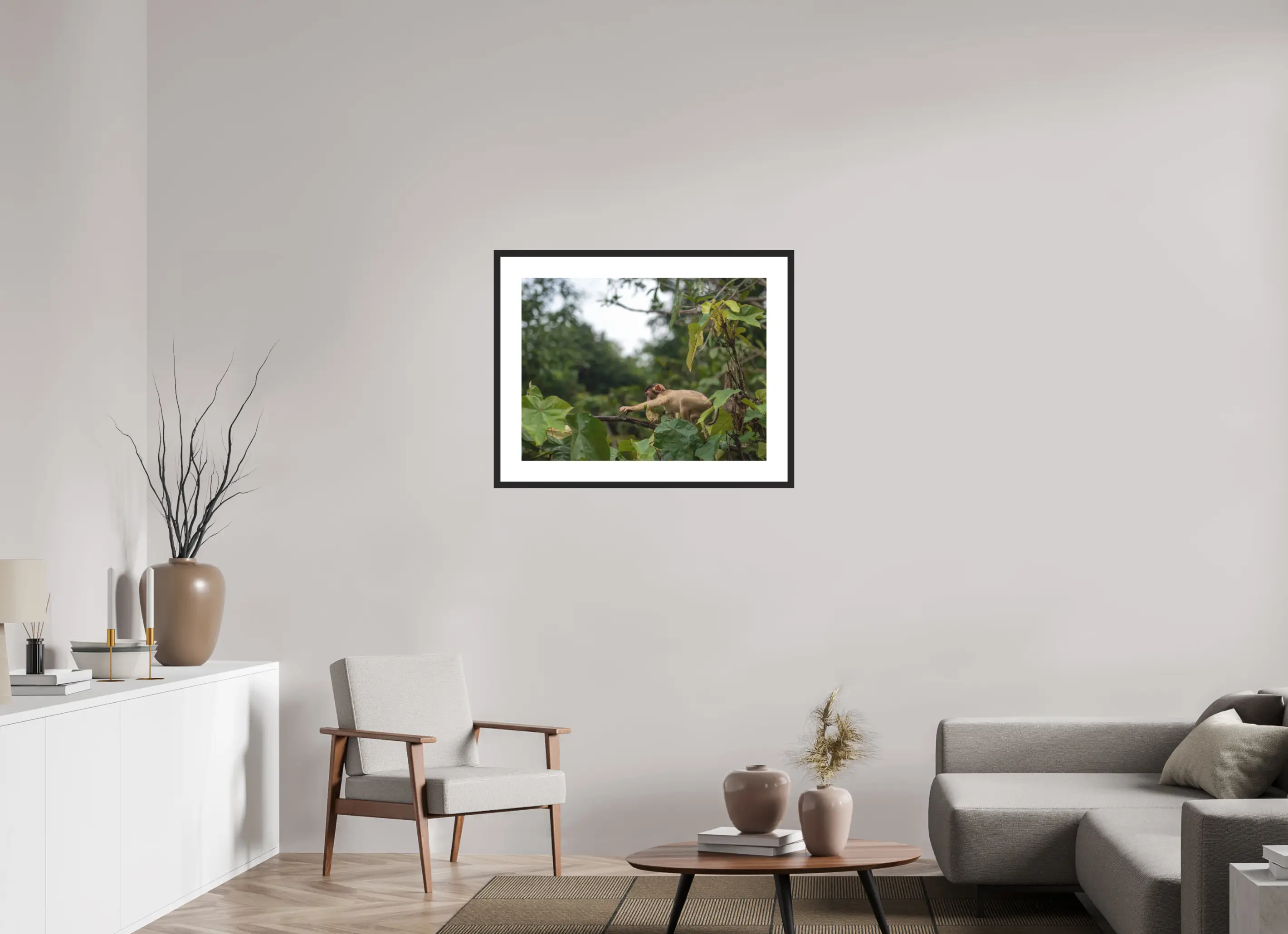 Fine art print “The Reach” featuring a young macaque in the rainforests of Borneo, displayed in a passepartout frame in a modern living room setting.