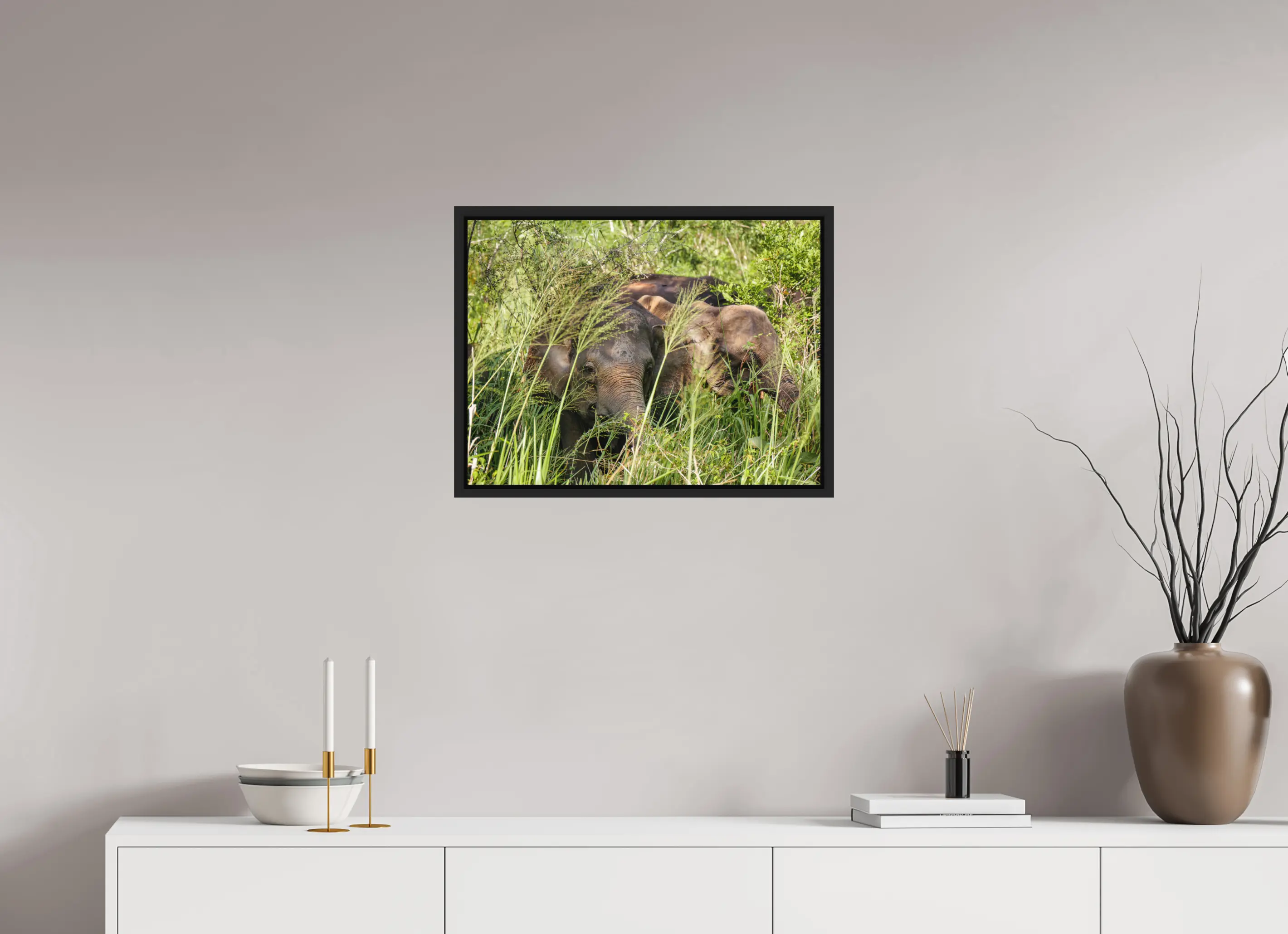 Fine art print “Gentle Giants” featuring wild asian elephants in the forests of Sri Lanka, displayed in a floater frame in a modern living room setting.