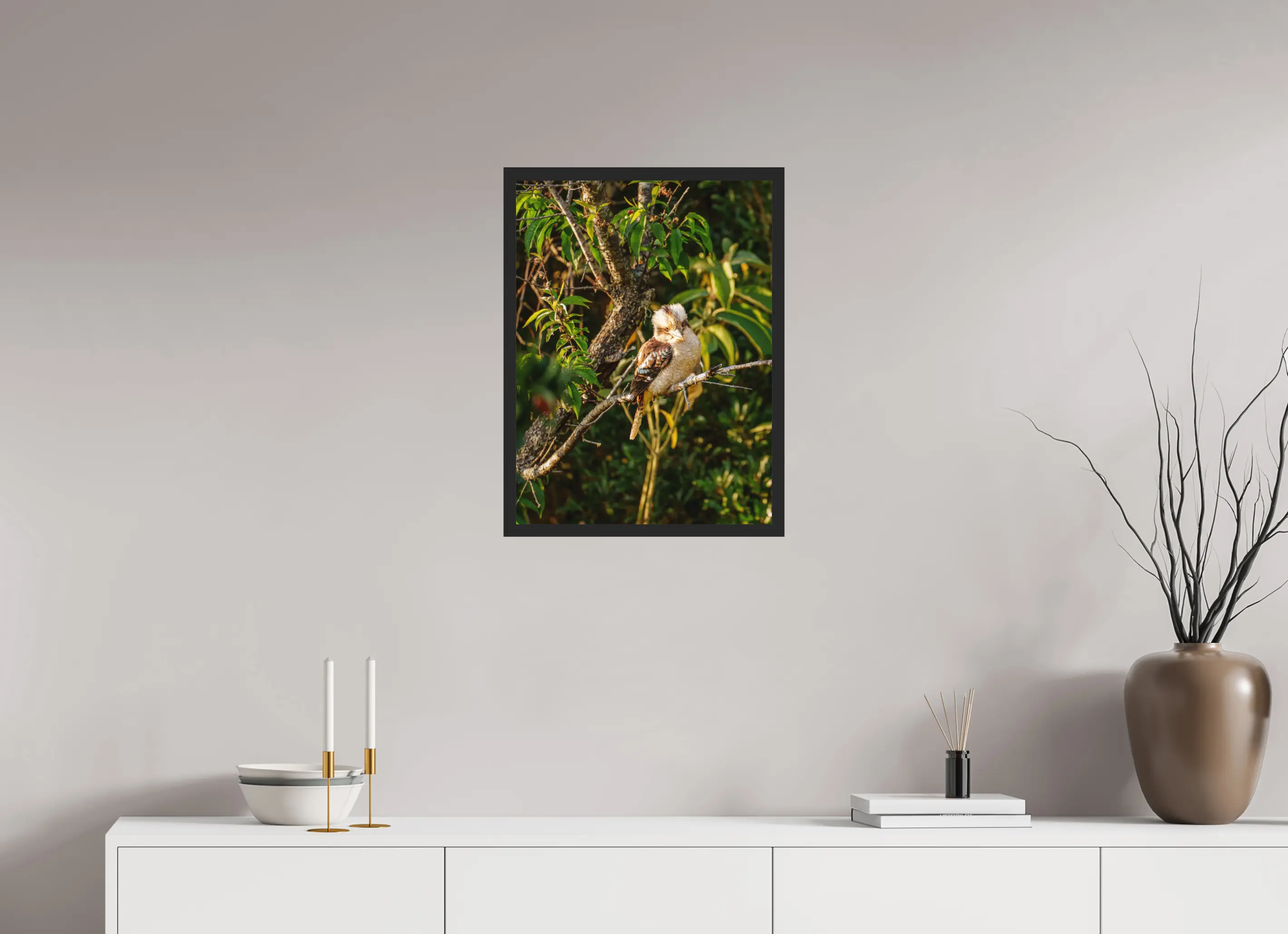 Fine art print “Laughter of the Forest” featuring a laughing kookaburra surrounded by green foliage in warm afternoon light, displayed classic framed in a modern living room setting.