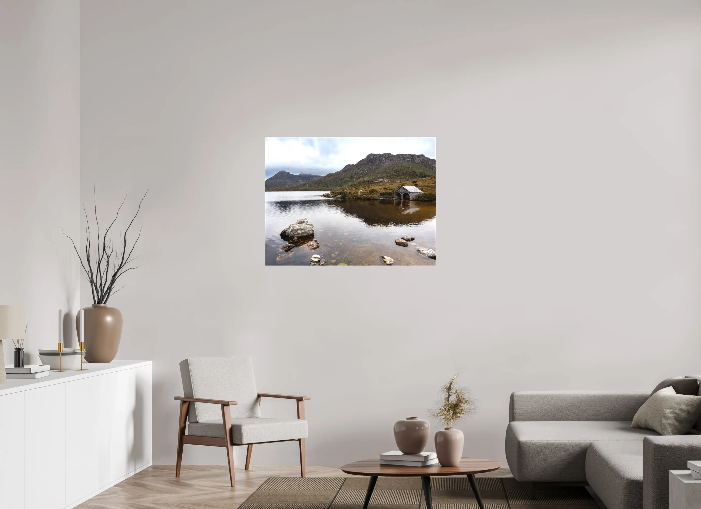 Fine art print “Presence” featuring a wooden boathouse on the calm waters of Dove Lake beneath Cradle Mountain in Tasmania, displayed on a premium canvas print in a modern living room setting.