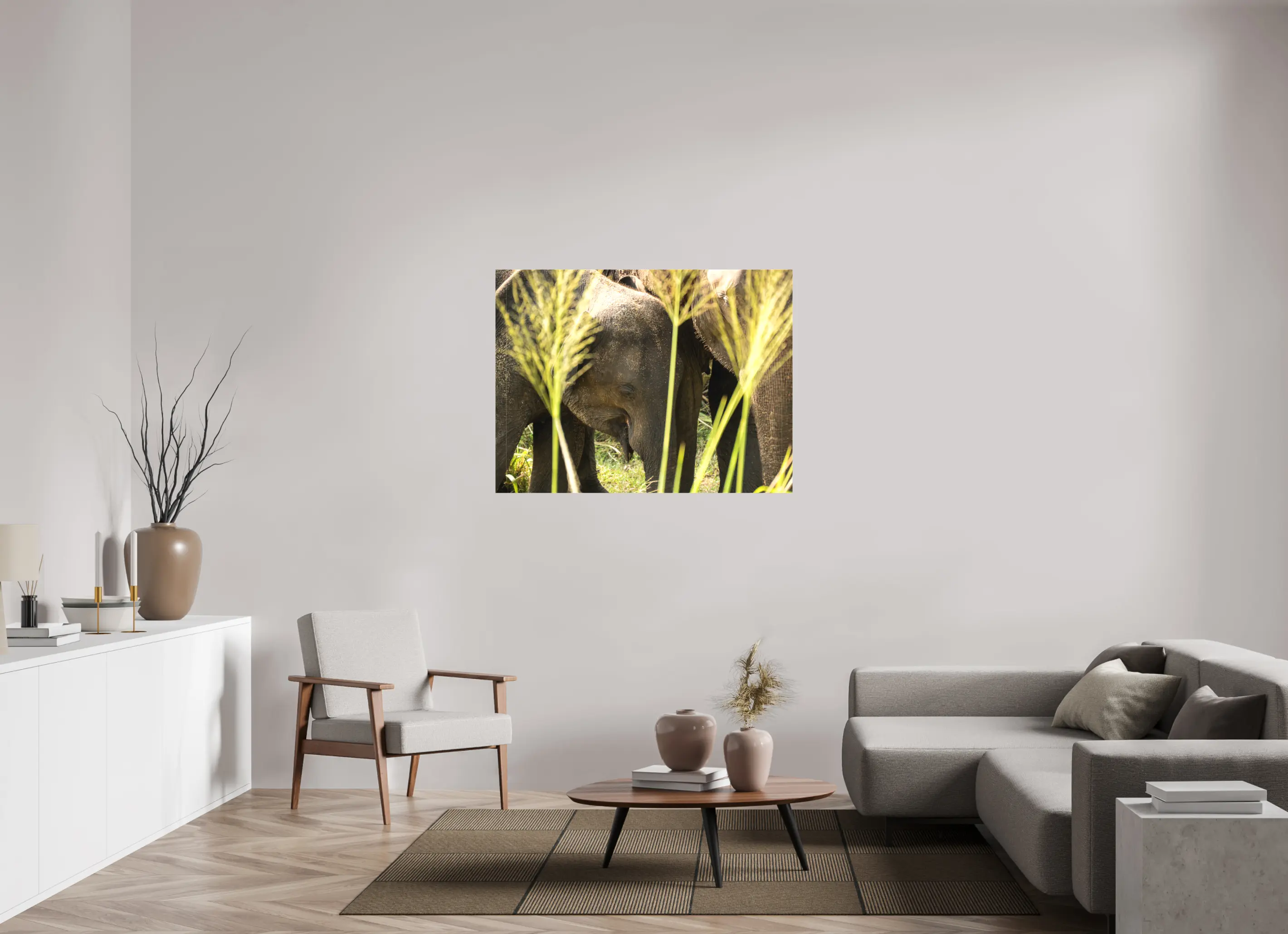 Fine art print “Protection of the Herd” featuring a group of Asian elephants huddled closely together in the tall grasslands of Sri Lanka, displayed on a premium canvas print in a modern living room setting.
