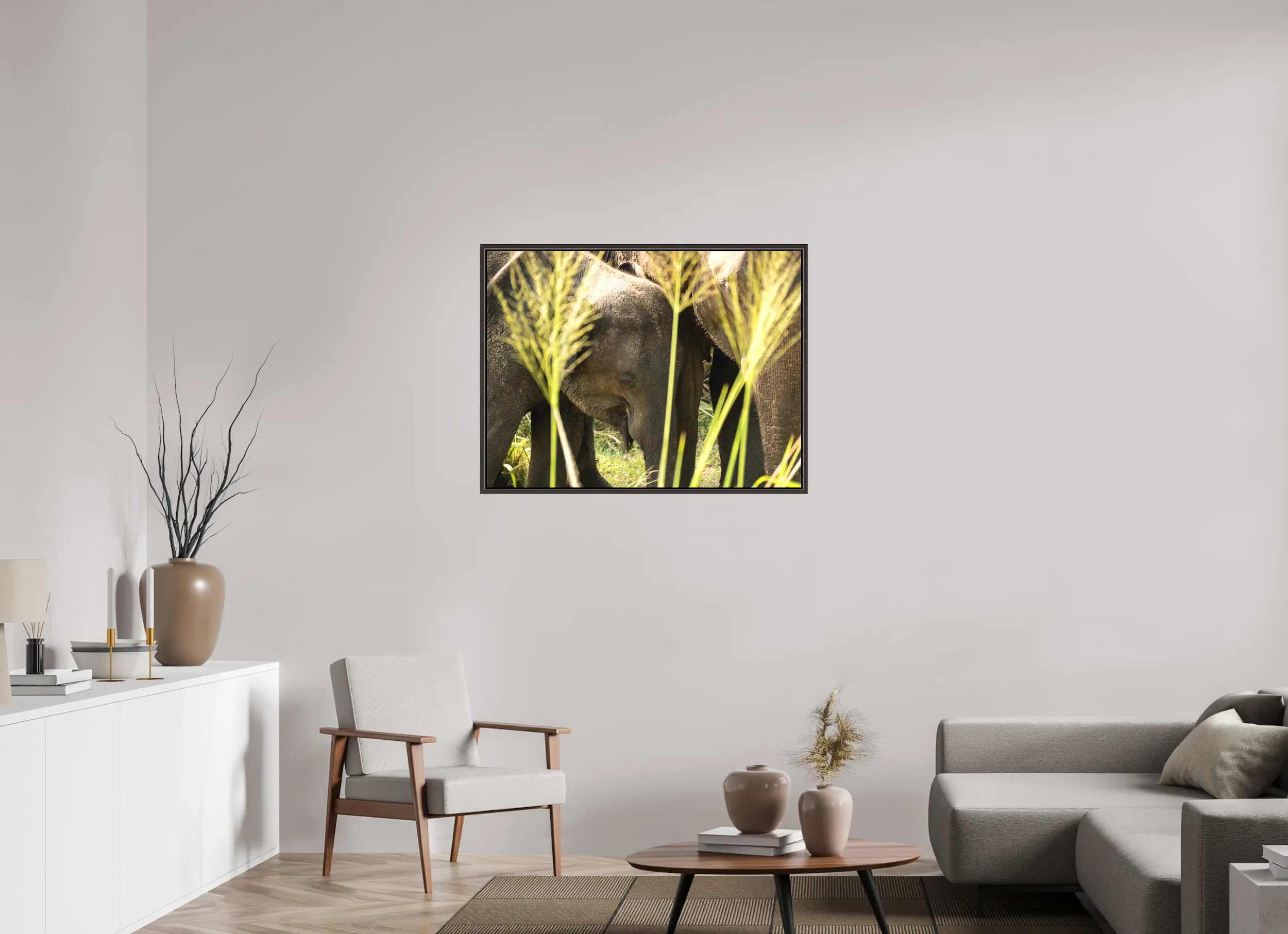 Fine art print “Protection of the Herd” featuring a group of Asian elephants huddled closely together in the tall grasslands of Sri Lanka, displayed on a premium framed canvas print in a modern living room setting.