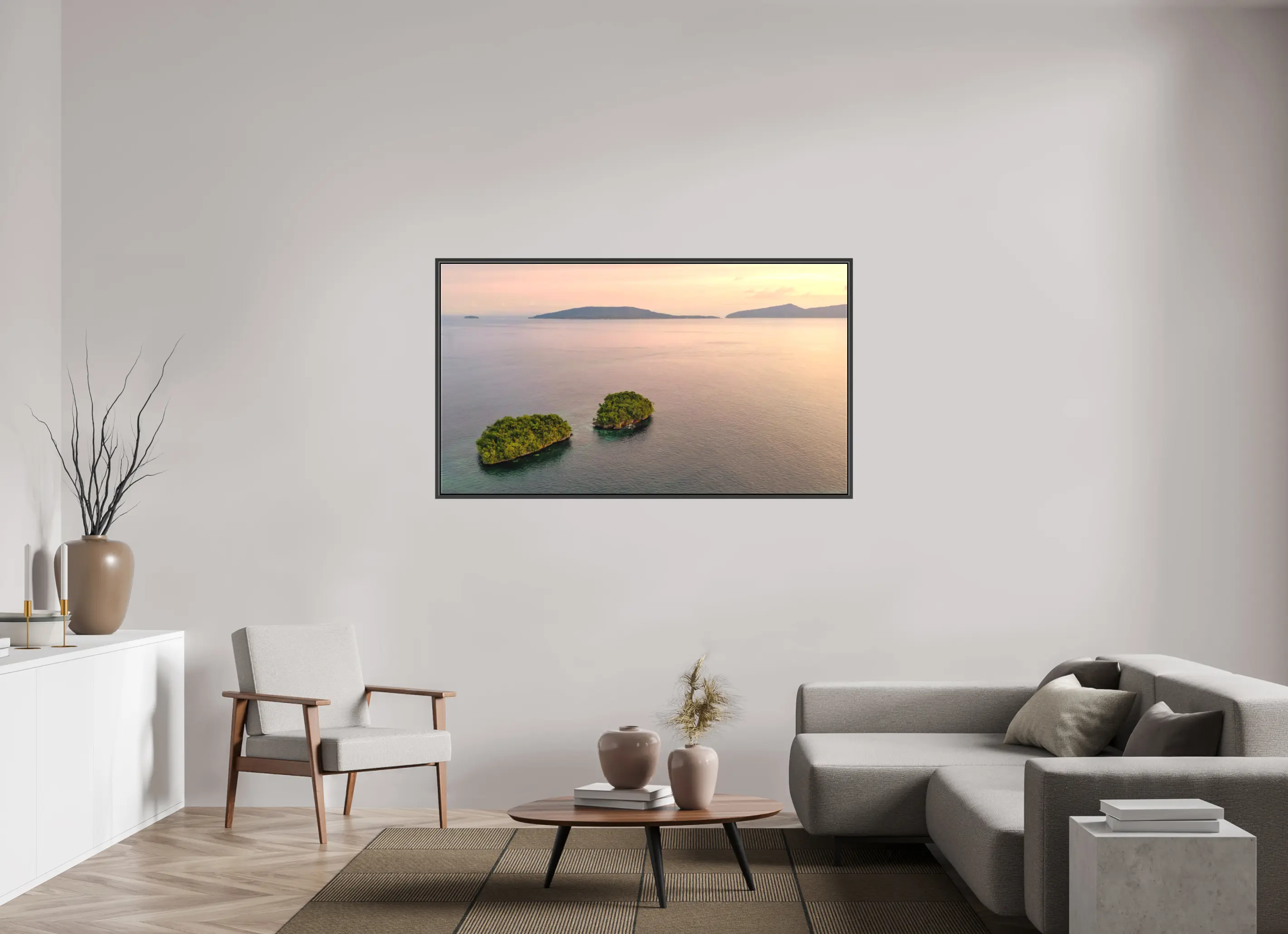 Fine art print “Siblings” featuring an aerial view of two small lush islands surrounded by calm pink waters at sunset in Raja Ampat Indonesia, displayed on a premium framed canvas print in a modern living room setting.