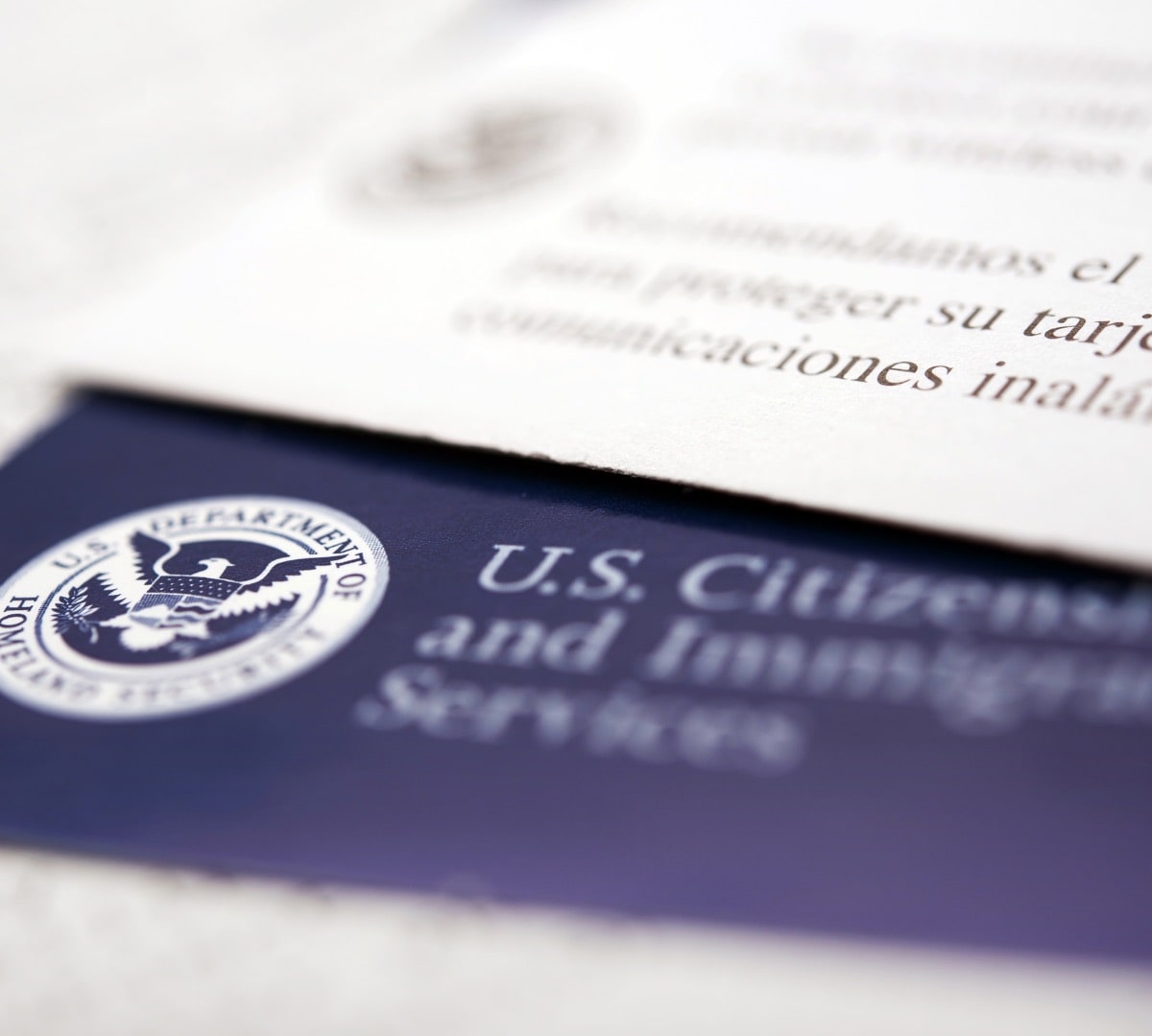 Close-up of U.S. Citizenship and Immigration Services (USCIS) documents related to I-9 compliance and ICE worksite audits in 2025.