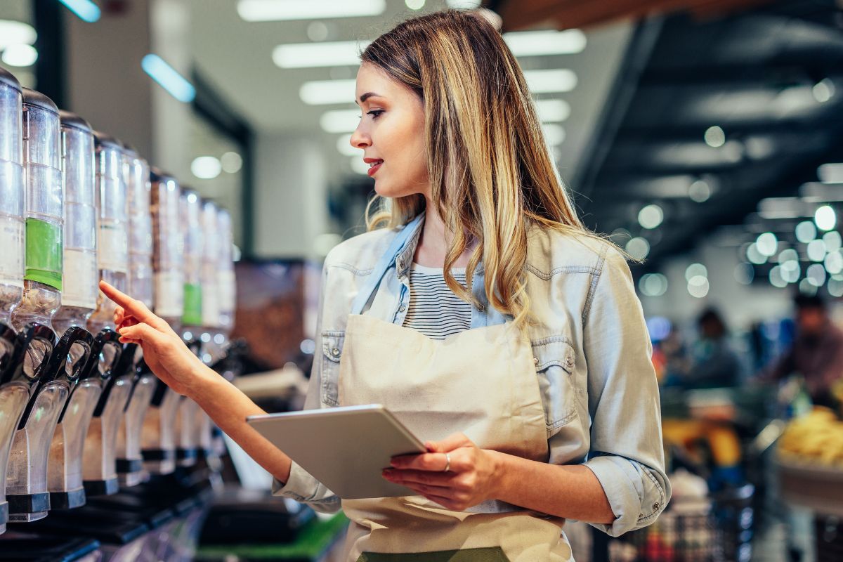 Retail worker managing inventory during seasonal hiring surge, highlighting the importance of I-9 compliance in retail and seasonal employment.