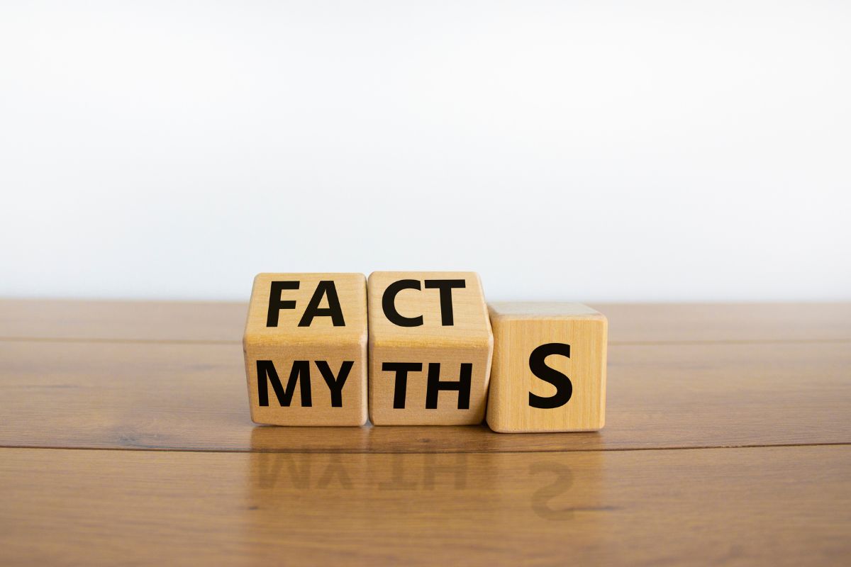 Wooden blocks showing the words “FACTS” and “MYTHS” side by side, symbolizing common E-Verify myths versus facts for HR compliance.