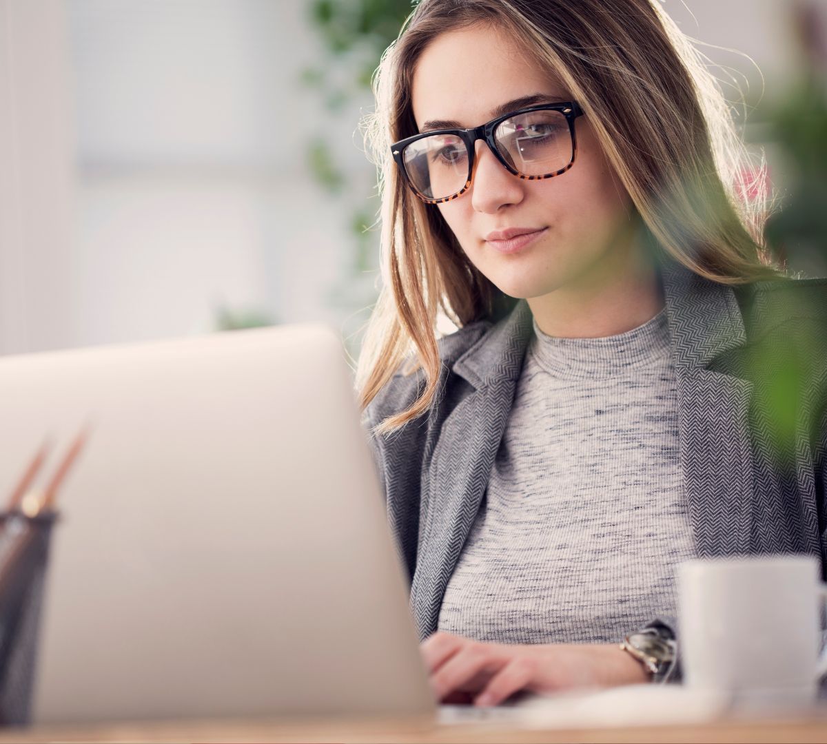 Close-up of an HR professional reviewing I-9 compliance details on a laptop as part of an integrated HRIS system.