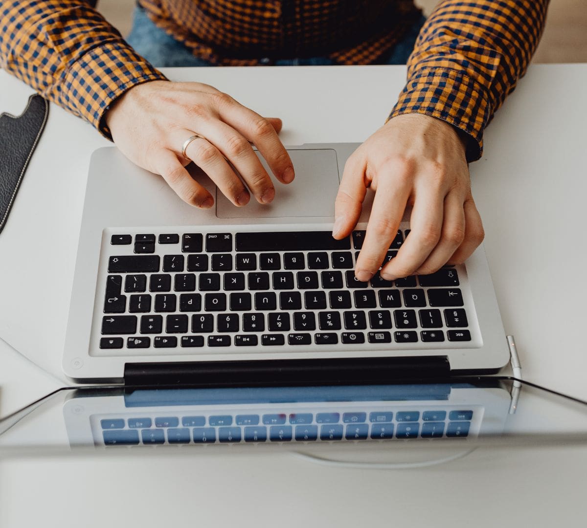 HR manager using a laptop to complete employee E-Verify and I-9 compliance forms for hiring in 2026. Category: E-Verify