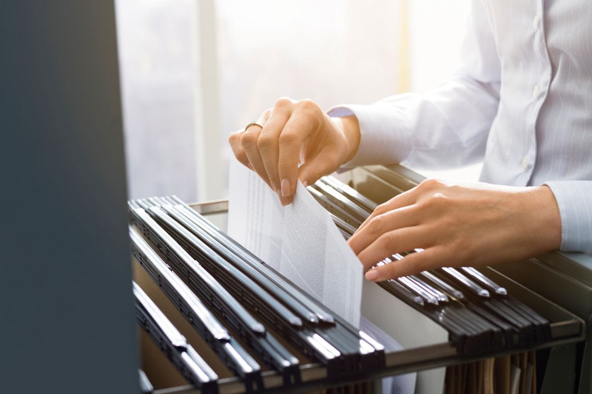 HR professional organizing employee records to determine how long to keep Form I-9 files for compliant retention 