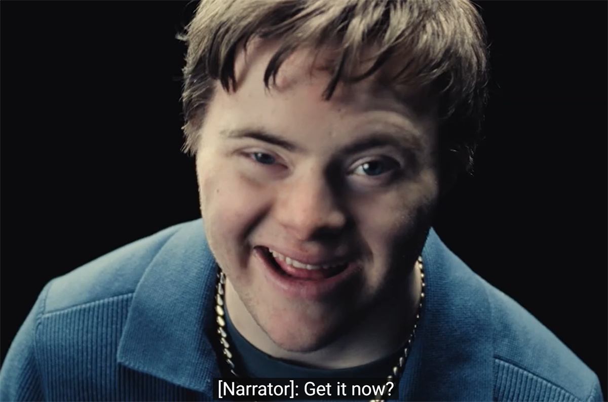 Campaign still frame shows a close-up of our narrator looking directly up at us with a humorous expression. Caption reads, "[Narrator]: Get it now?"