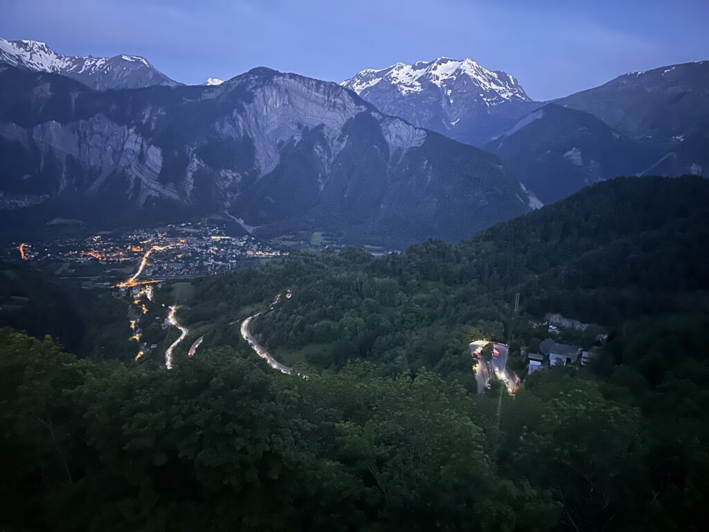 A scenic view of a town and mountains at night