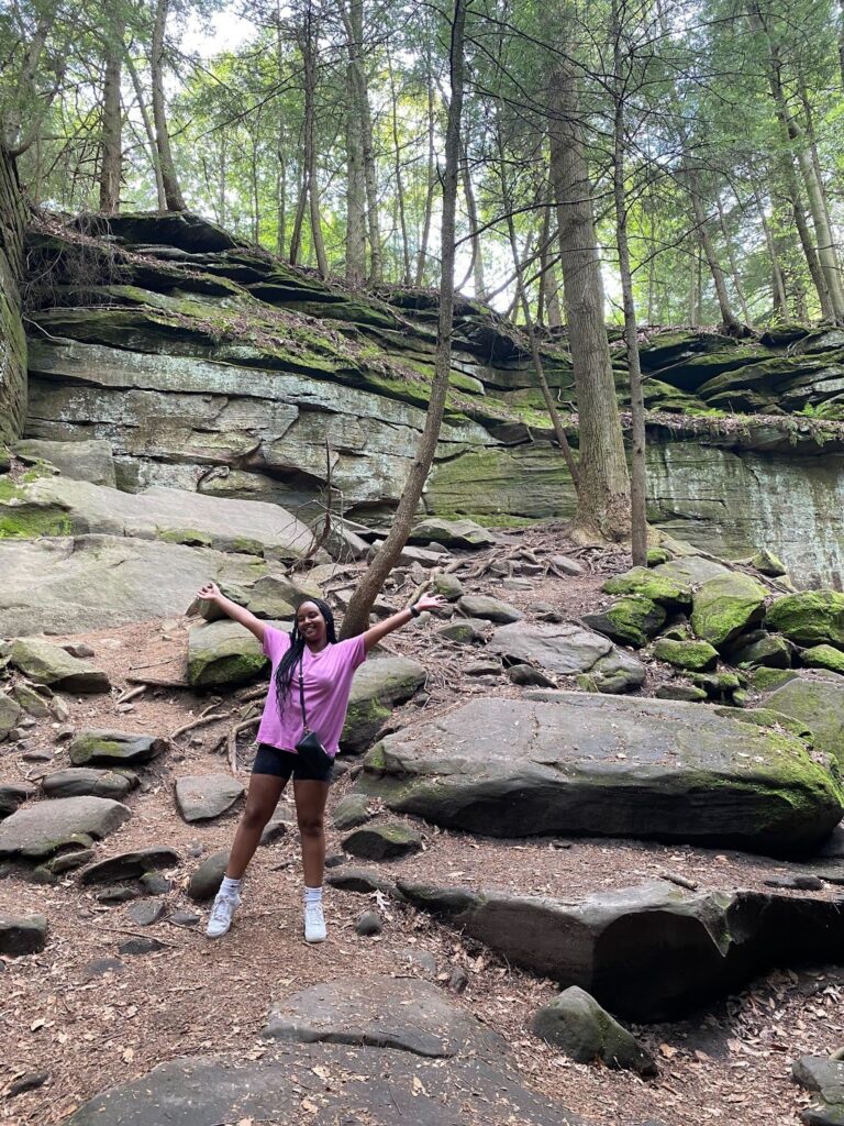 A woman standing on top of a rock covered hillside