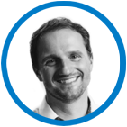 A black and white photo of a smiling man