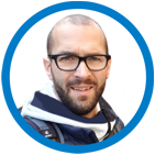 A man with glasses and a beard wearing a scarf