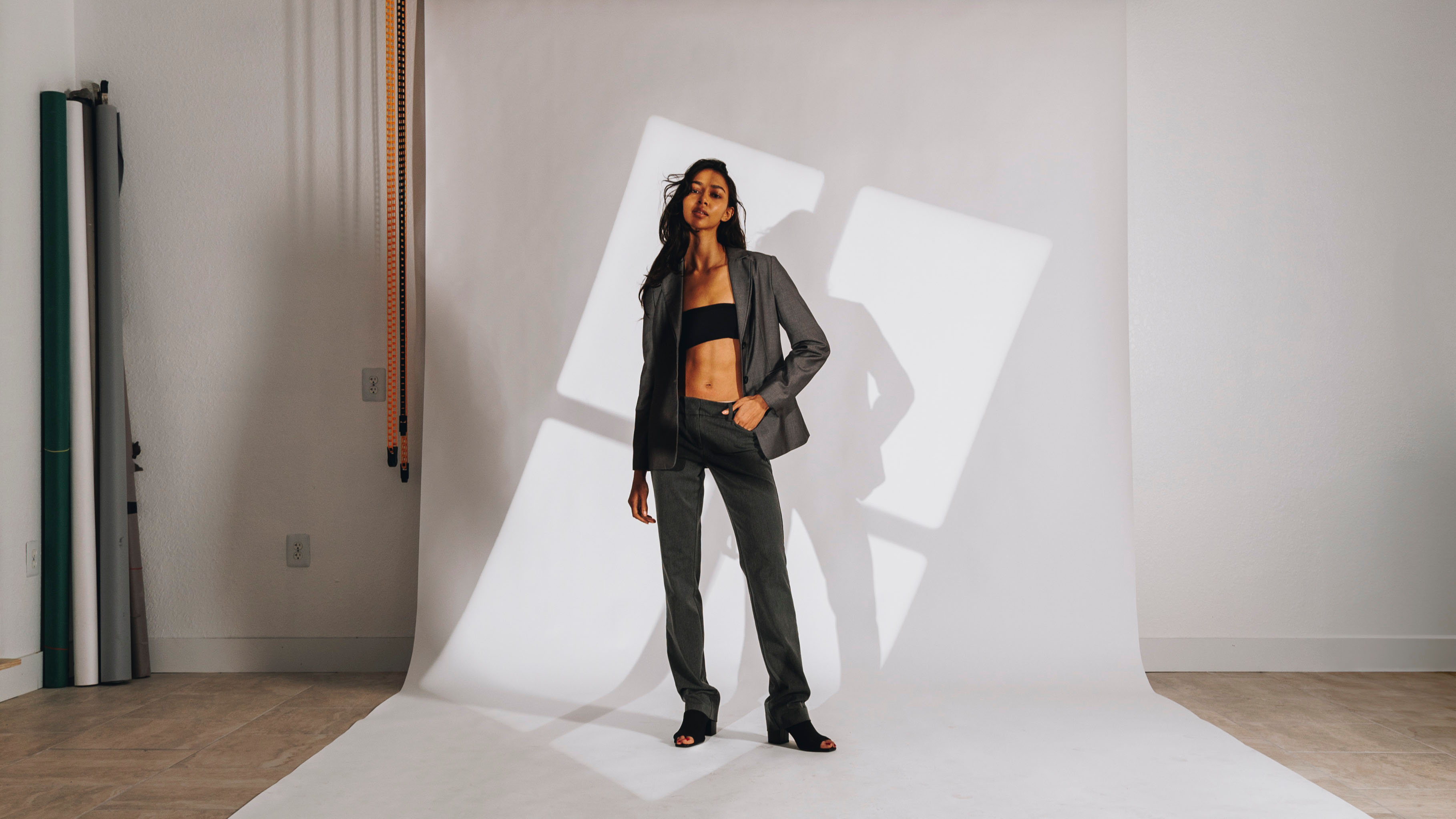 Model on white background with window light on the background, in a clean empty studio