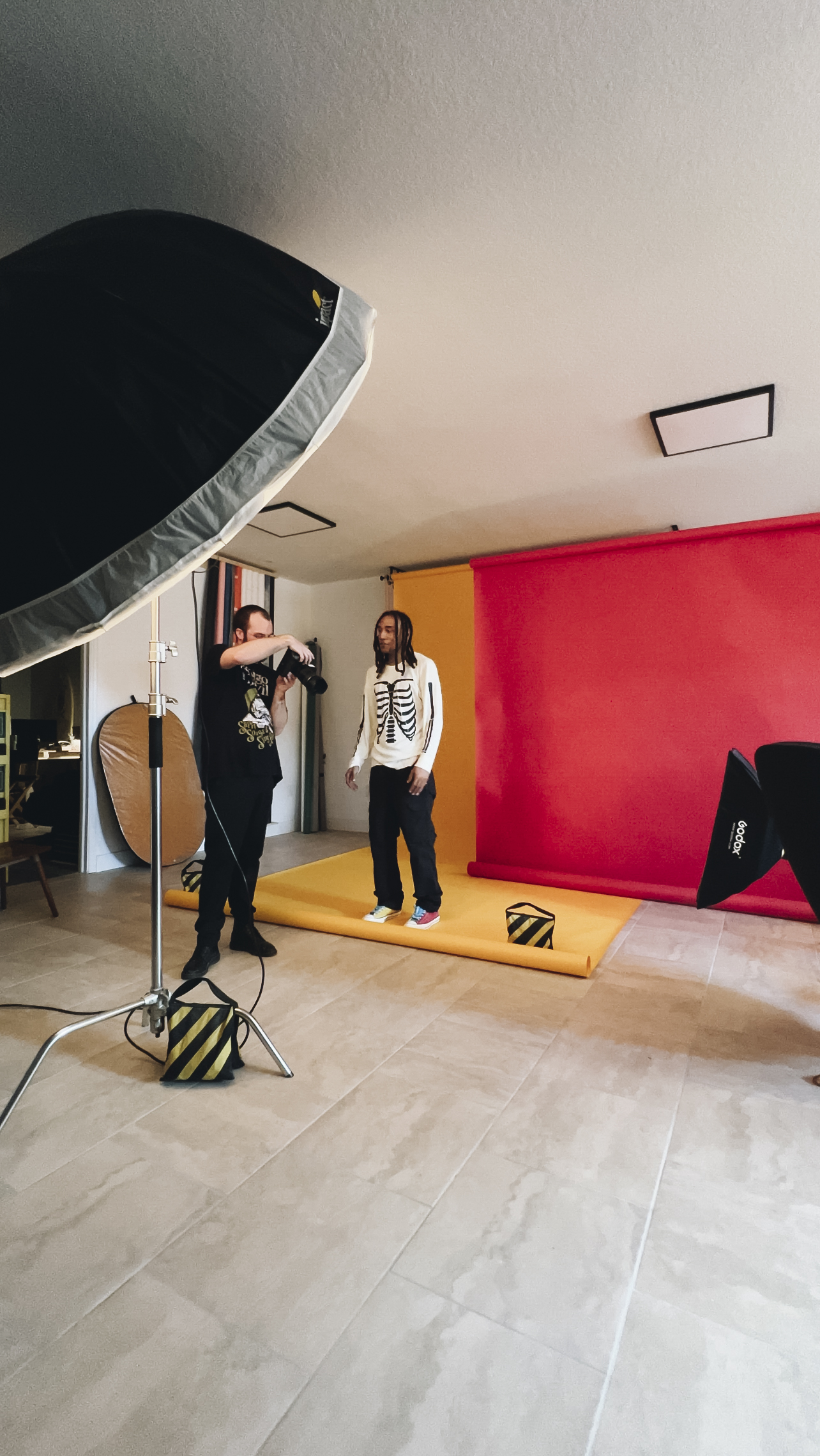 Photographer shooting a portrait session at BLNK Studios with colored seamless backdrops and studio lighting