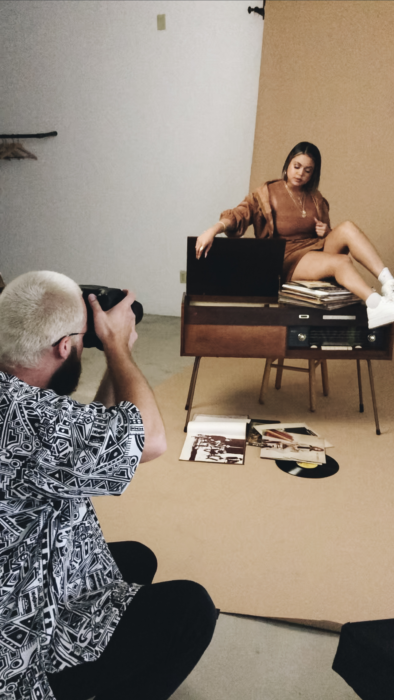 Photographer working on a portrait session at a studio rental with seamless backdrop and props