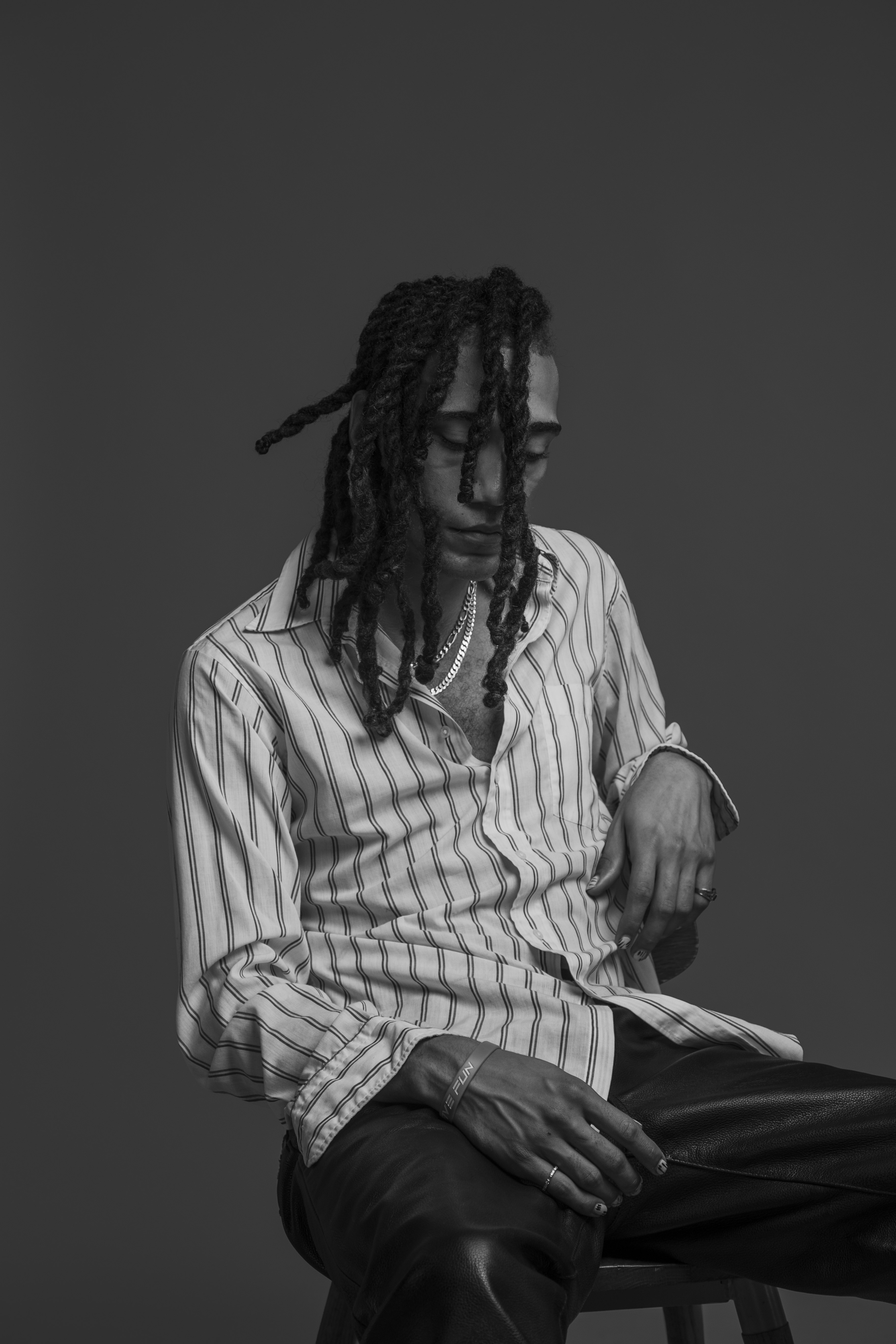 Black and white studio portrait taken with a single light setup at BLNK Studios, showing directional lighting and subject separation from background