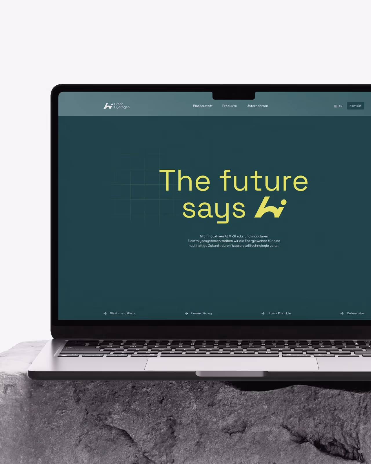 Mockup eines MacBooks auf einem Stein, welche die dunkelgrüne Startseite von H2i GreenHydrogen's neuer Webflow Website zeigt. Der Screen zeigt die Headline in limegrün: The future says h2i
