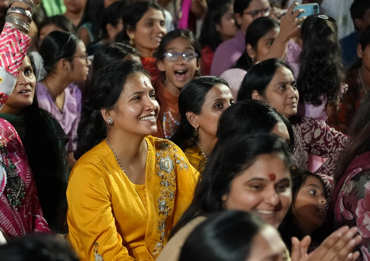 Smiling temple community members watching the celebration together.