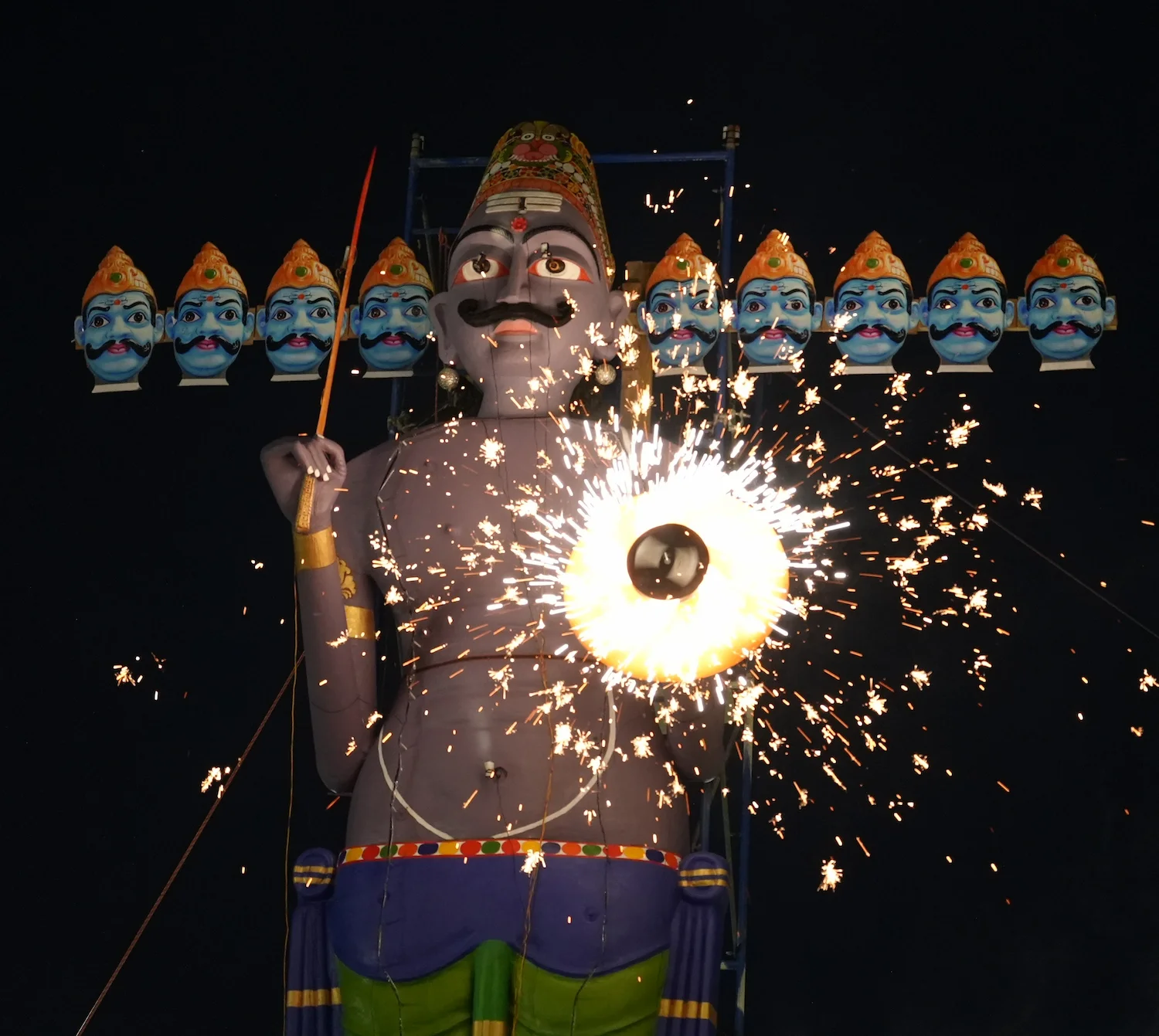 The ten-headed Ravan effigy illuminated by sparks during the 2025 Dusshera celebration.