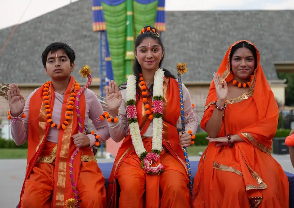 Costumed young performers and community members standing before the Ravan effigy.