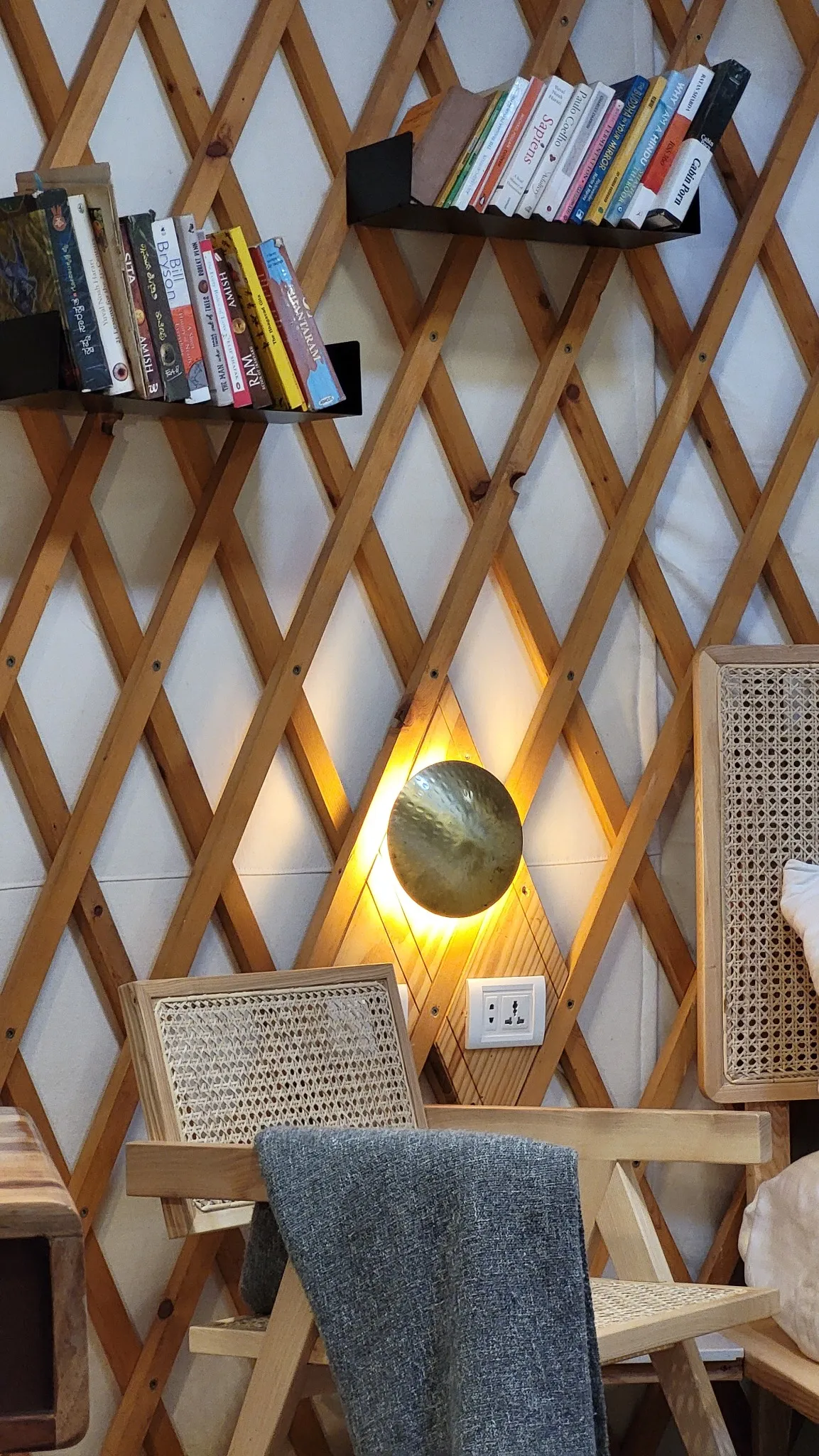 Yurt with a Cozy reading nook with books, wooden lattice wall, and glowing circular lamp