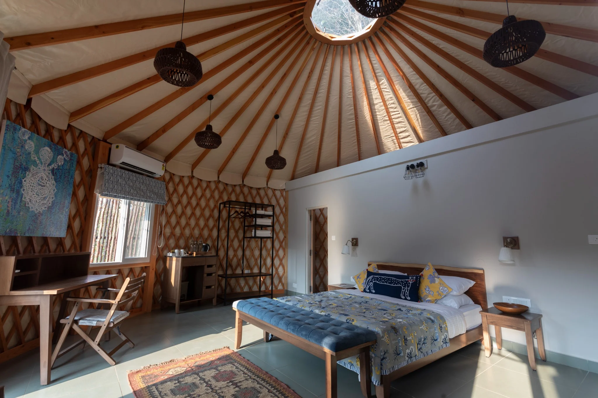 Cozy bedroom in a yurt-style room with wooden ceiling and artistic decor