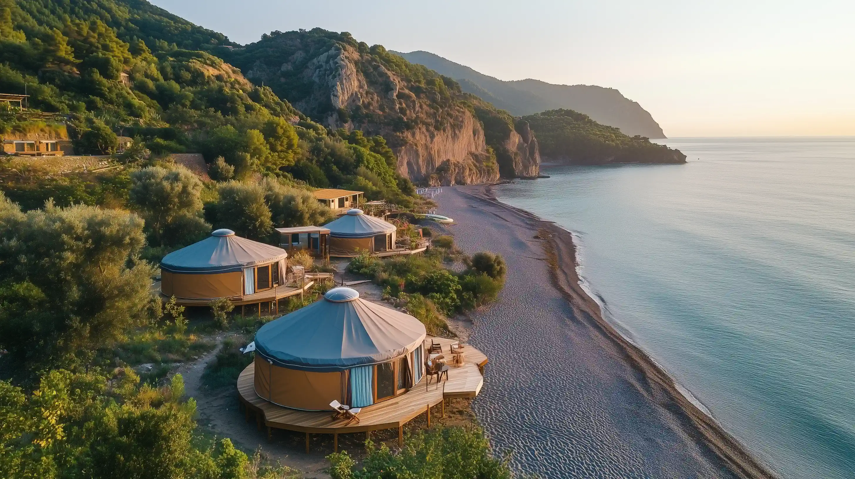 Circular yurt-like cabins on wooden deck overlooking rocky coastal landscape