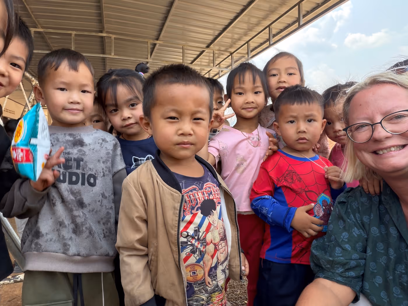 Bildet viser en gruppe barn i Laos som står oppstilt